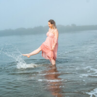 Maternity photo of a woman walking on the beach. Pregnant woman walking on the beach – NYC maternity photo